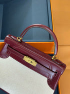 Hermes kelly 25 with red leather trim and a white canvas body